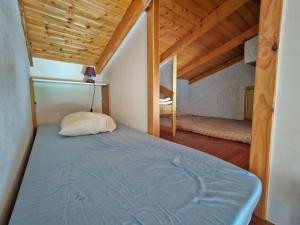 un lit dans une chambre avec un plafond en bois dans l'établissement Maisonnette proche plage et commerces, animaux admis, parking privé - FR-1-476-33, à La Faute-sur-Mer