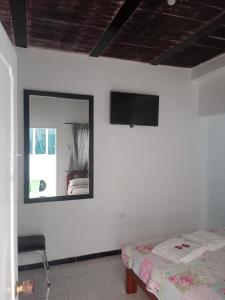 a bedroom with a mirror and a bed and a chair at D apartaestudio amoblado central con cocina y baño in Chiquinquirá +1 photo
