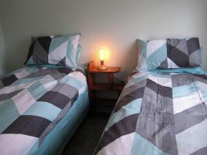 a bedroom with two beds and a candle on a night stand at The Grumpy Trout Lodge #Outdoors on our #doorstep! in Turangi +34 photos