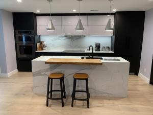 a kitchen with a sink and two bar stools at Perfectly Located Luxurious Home in San Francisco