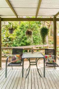 a table and two chairs on a wooden deck at Bush N Beach Sunshine Coast near Eumundi & Noosa in Doonan