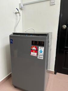 a small refrigerator with stickers on it next to a door at Rafeeqs Homestay in Teluk Intan