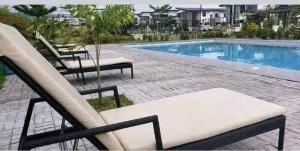 a pool with two lounge chairs next to at Gavin Guest House in General Santos
