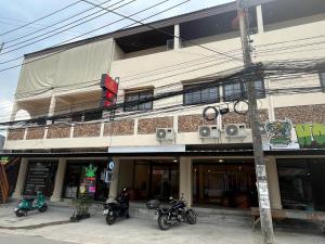 苏梅岛Tian Ming Hostel的一栋建筑前停放着摩托车