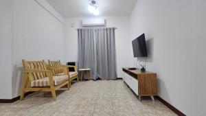 a living room with a tv and chairs and a table at Vitramu Campana I in Campana