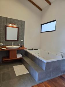 a bathroom with a tub and a sink and a mirror at Monteverde Casa Mia, near main attractions and town! in Monteverde Costa Rica +57 photos