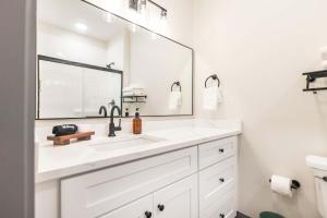 ein weißes Badezimmer mit Waschbecken und Spiegel in der Unterkunft Bold & Floral Little Richard Getaway in Macon + 10 Fotos