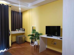a living room with a tv and a desk with a tvictericter at ๋Jongluxpakdee โรงแรมจงรักษ์พักดี in Uttaradit