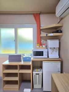 a kitchen with a counter with a microwave and a refrigerator at Happy Garden Guesthouse in Seoul