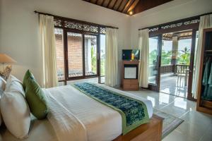 Un dormitorio con una cama grande y grandes ventanales. en Suar Villa Ubud, en Ubud