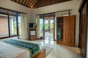 Un dormitorio con una cama y un televisor. en Suar Villa Ubud, en Ubud 53 fotos más