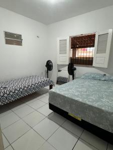 a bedroom with two beds and a window in it at Casa de praia in Luis Correia