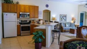 a kitchen and living room with a white refrigerator at Heron's Nest in Port Saint Lucie