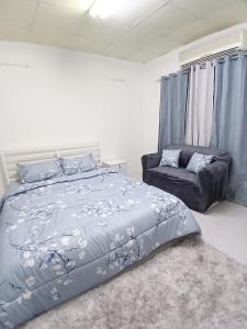 une chambre avec un lit et un canapé dans l'établissement Al Ain Blue, à Al-Aïn