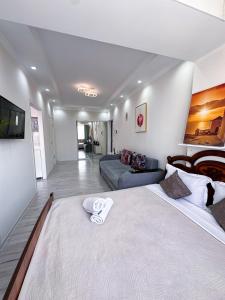 a bedroom with a large bed and a couch at Квартира в самом центре города с видом на город in Almaty