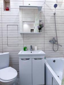 a white bathroom with a toilet and a sink at Квартира в самом центре города с видом на город in Almaty +7 photos