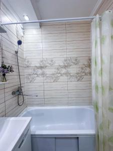a bathroom with a white tub and a shower at Квартира в самом центре города с видом на город in Almaty