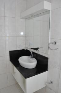 a white bathroom with a sink and a mirror at Hotel Premier in Santa Rita +30 photos