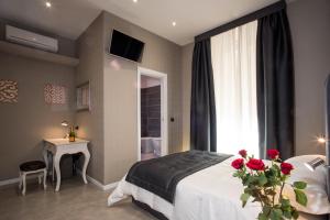 a bedroom with a bed and a window with red roses at Roma 2B in Rome