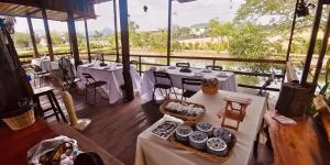 a restaurant with white tables and chairs on a deck at Manee Garden in Ban Fang Mun