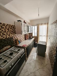 una cocina con estufa y encimera en شقة للكراء اليومي في الحسيمة, en Alhucemas