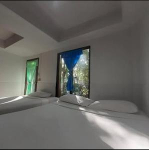 a bedroom with two beds and a window with at Phangan Cosy Bungalow - ban tai in Baan Tai