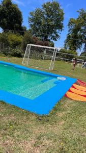 a swimming pool with a soccer net on the grass at Cabañas en Valdivia in Valdivia +3 photos