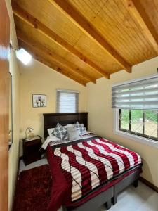a bedroom with a bed with a red and white blanket at Cabañas en Valdivia in Valdivia