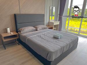 a bedroom with a large bed with a large window at Staycation Homestay 65 Liberty Grove Near Airport in Kuching