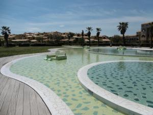 a large swimming pool with a bench in the water at Port Leucate T4 Duplex Climatisé, 6 Pers, Vue Chenal, Wifi, Parking - FR-1-798-56 in Leucate