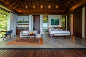 a living room with two beds and a table at Rancho Pacifico - Boutique Hotel for Adults in Uvita +124 photos