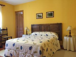 a bedroom with a bed and two tables with lamps at Casa Rural Sierra de Tormantos in Guijo de Santa Bárbara +50 photos