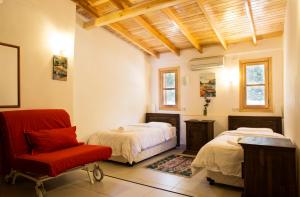 um quarto com 2 camas e uma cadeira vermelha em Villa Aktan em Kas