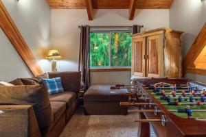 a living room with a couch and a foosball table at `Antler Ridge` Hot tub, Wifi, BBQ, River Access! in Packwood