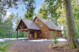 a log cabin with a gambrel roof in the woods at `Antler Ridge` Hot tub, Wifi, BBQ, River Access! in Packwood