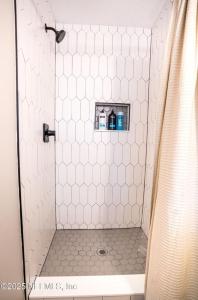 a shower with a white tiled shower stall with at Family Fun Retreat - Heated Pool & Arcades in Jacksonville