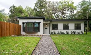 a small white house with a fence at Family Fun Retreat - Heated Pool & Arcades in Jacksonville