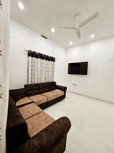 a living room with a couch and a flat screen tv at Mariya Home Stay, Malampuzha in Kanjikode