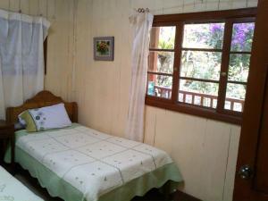 ein kleines Schlafzimmer mit einem Bett und einem Fenster in der Unterkunft Mandor Machu Picchu in Machu Picchu