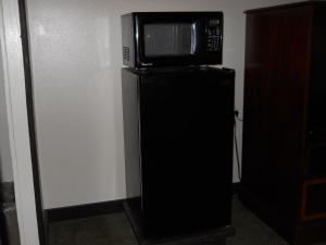 eine Mikrowelle auf einem schwarzen Kühlschrank in der Unterkunft Value Inn Motel - Milwaukee Airport South in Oak Creek