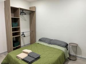 a bedroom with a green bed and a stool at Lovely Emile Zola apartment in Laxou