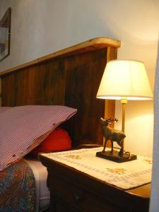 a lamp on a table next to a bed at B&B Ploncher in Chiavenna