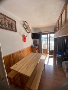 a living room with a wooden table in a room at Appartement Cosy Tout Confort in Les Angles