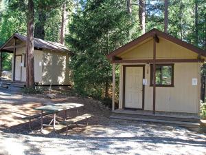un cobertizo con una mesa de picnic y un banco delante de él en Yosemite Lakes Bunkhouse Cabin 27 en Harden Flat