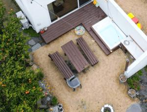 an overhead view of a patio with two benches and a house at Wasan Stay in Jeju in Jeju