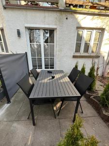 ブレーメンにあるFerienwohnung am Knoops Parkの家の前にピクニックテーブルと椅子2脚