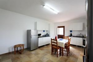 a kitchen with a table and chairs and a refrigerator at Horta Grande in Silves