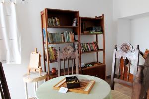 a room with a table and chairs and book shelves at Horta Grande in Silves