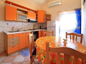 a kitchen with a table and a kitchen with orange cabinets at Apartments Đuričić in Lovište