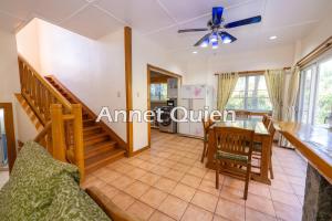 a dining room and living room with a dining table at 4 Bedroom Log Cabin in Camp John Hay Baguio in Baguio